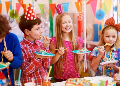 Smiling children enjoying cake at birthday party