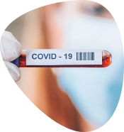 Hand holding a COVID-19 test tube with a blurred person in the background.