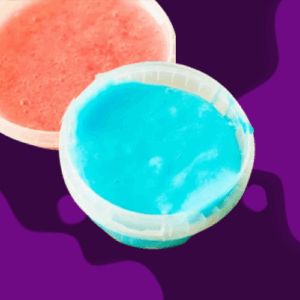 Two colorful gelatin desserts, one red and one blue, on a purple surface.