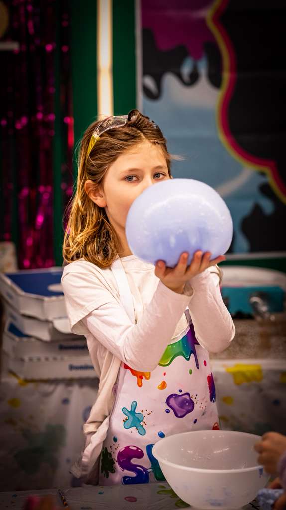 Girl holding large lavender soap bubble
