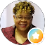 Smiling woman in gold headwrap with star badge